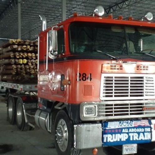 Red semi-trailer truck carrying wood