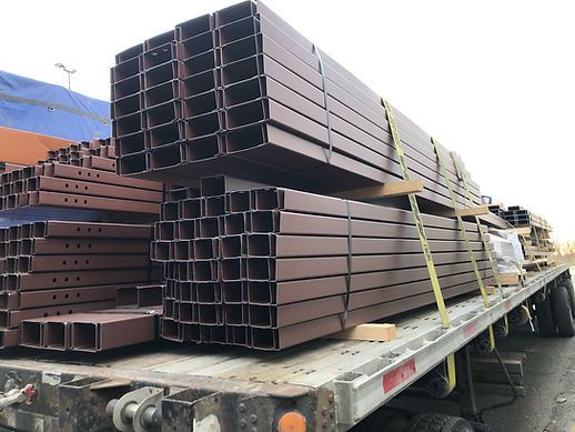 A truck is loaded with a stack of metal tubes