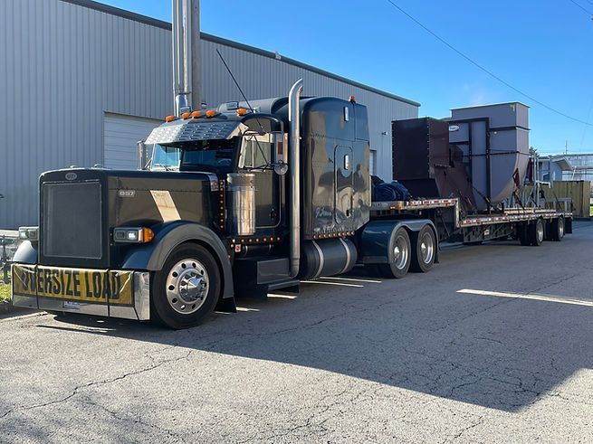 A large semi truck is parked in front of a building