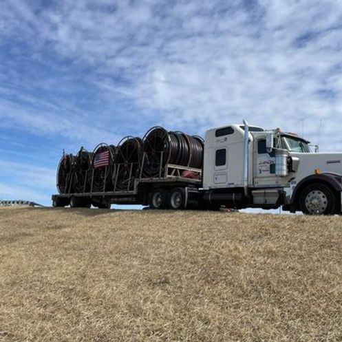 A semi truck is carrying a bunch of wires on a trailer
