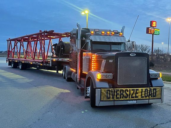 A semi truck is carrying an oversized load on a trailer