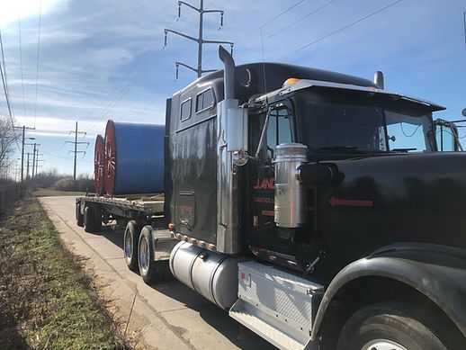 A black semi truck is parked on the side of the road