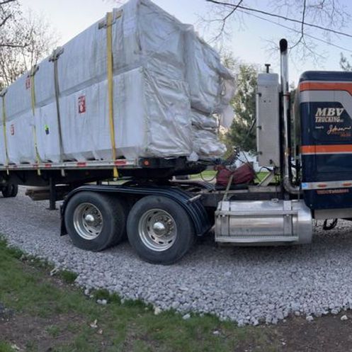 A semi truck is carrying a large container on the back of it