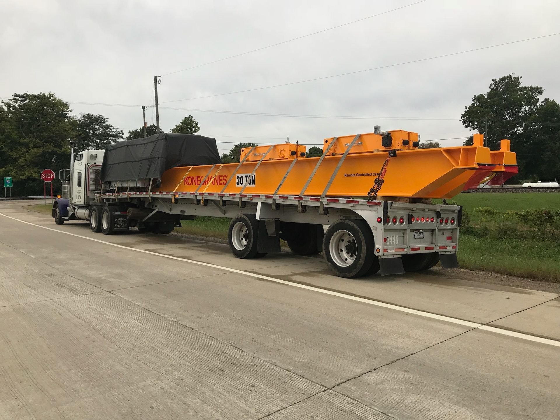 Red Semi Truck is Driving Down a Highway Carrying Wood