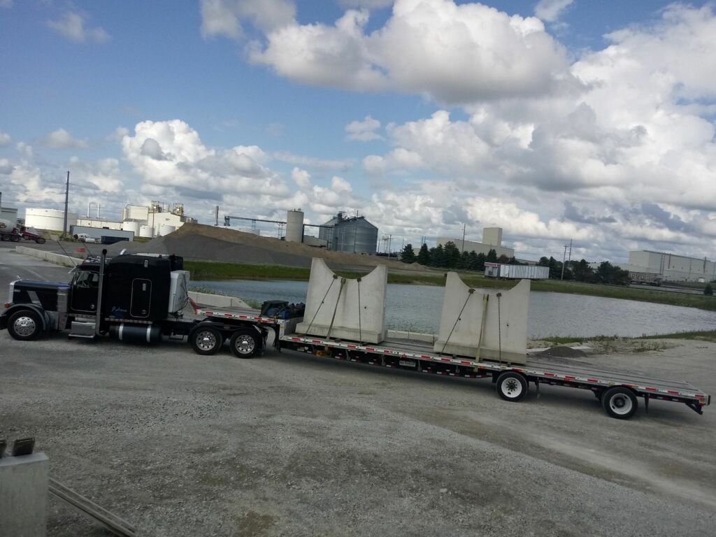 A semi truck is carrying concrete blocks on a trailer