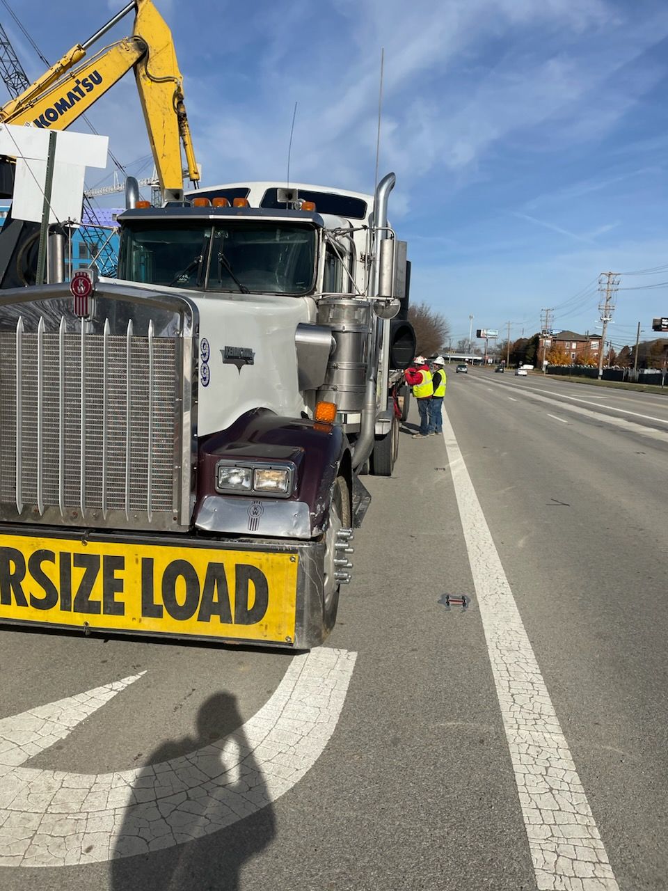 A large truck is parked on the side of the road with a yellow sign that says rsize load