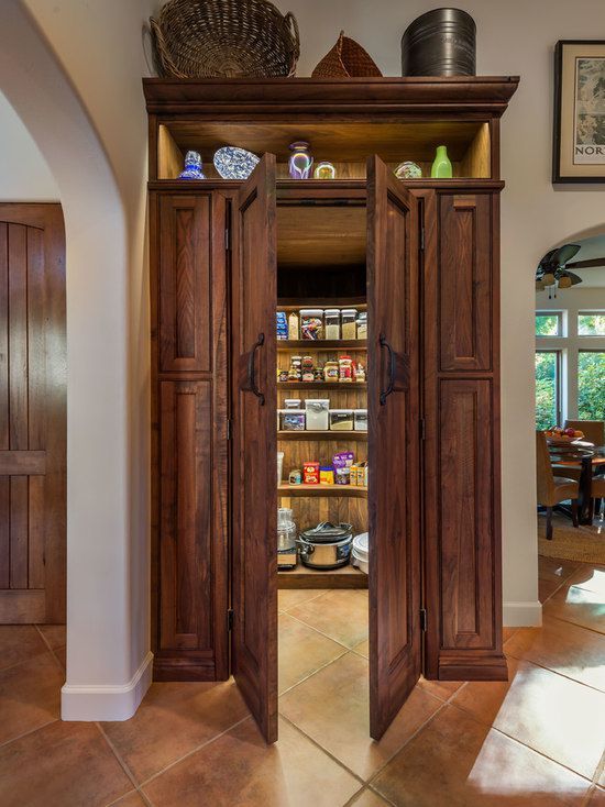 A pantry in a kitchen with the doors open