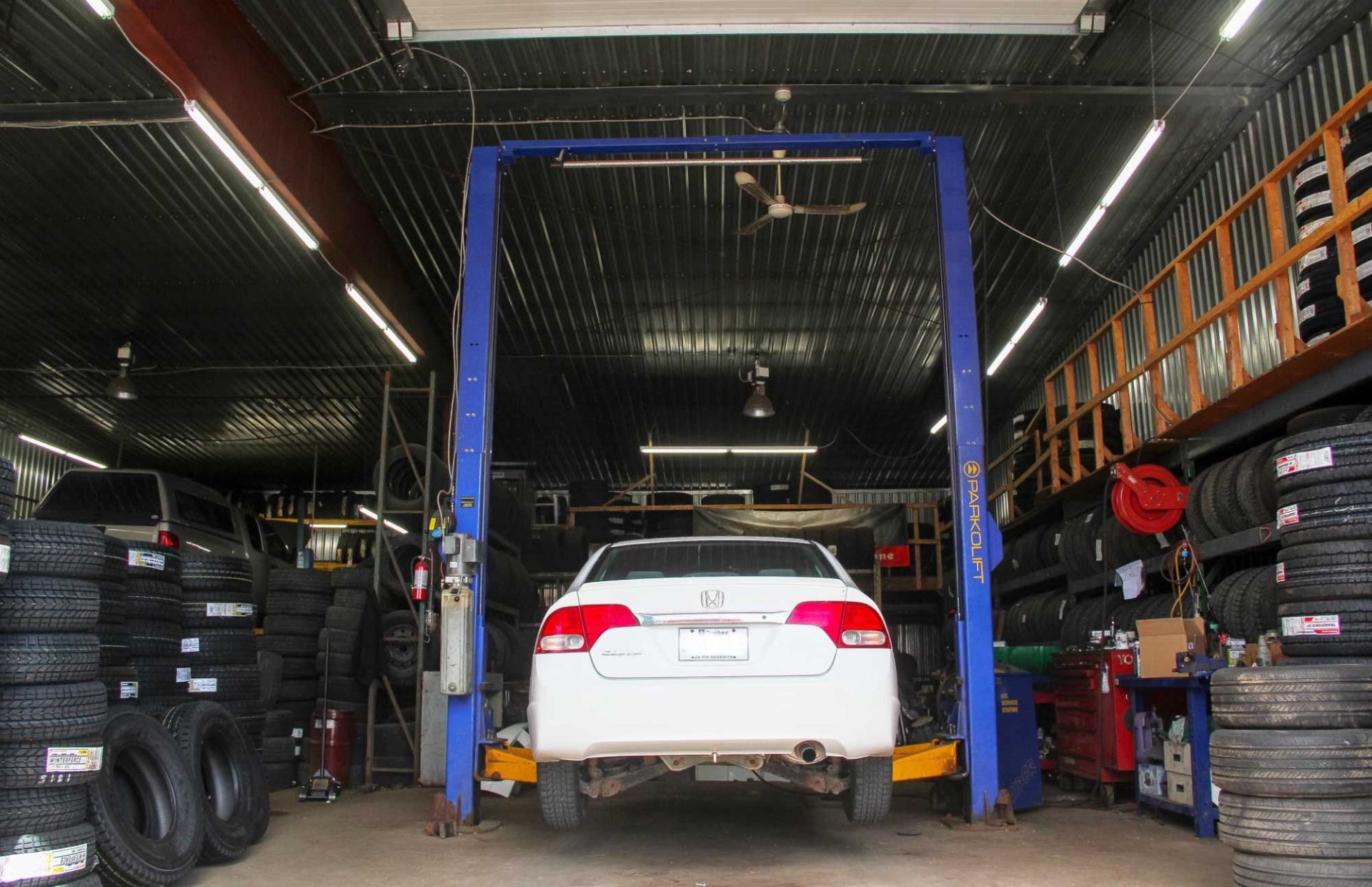 Car service station, cars being repaired and stack of tyres