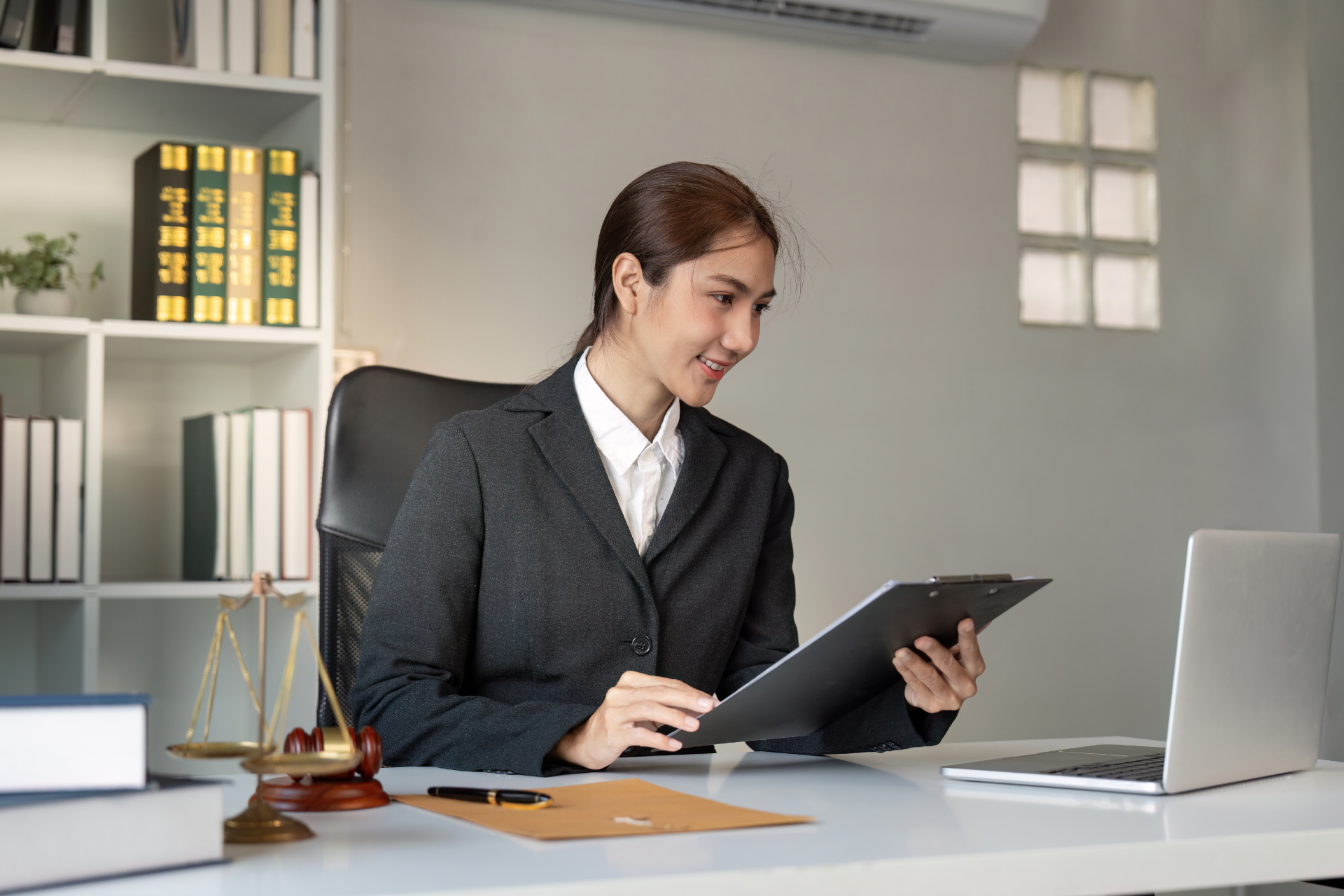 A woman is sitting on a couch talking on a cell phone while holding a piece of paper.