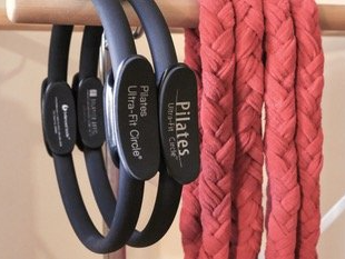 A bunch of pilates circles are hanging on a rack
