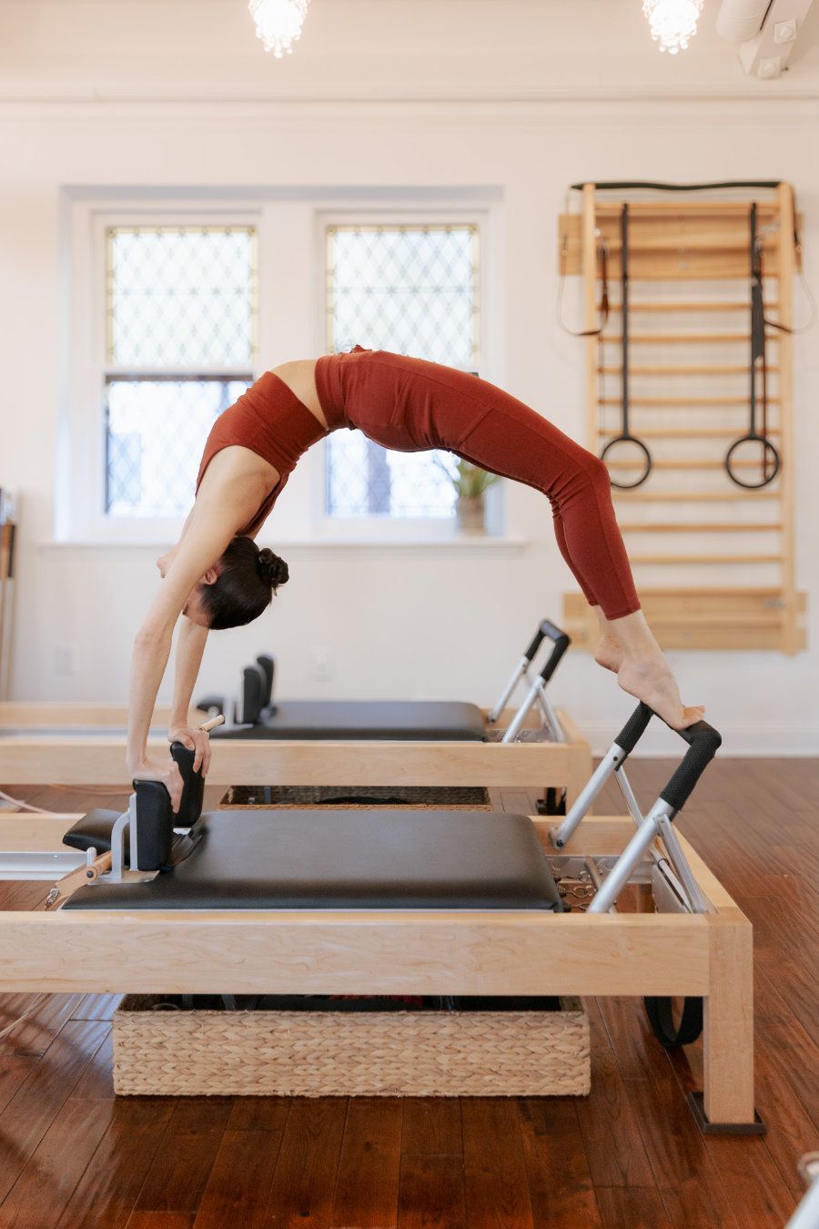 A woman is doing a yoga pose on a pilates machine