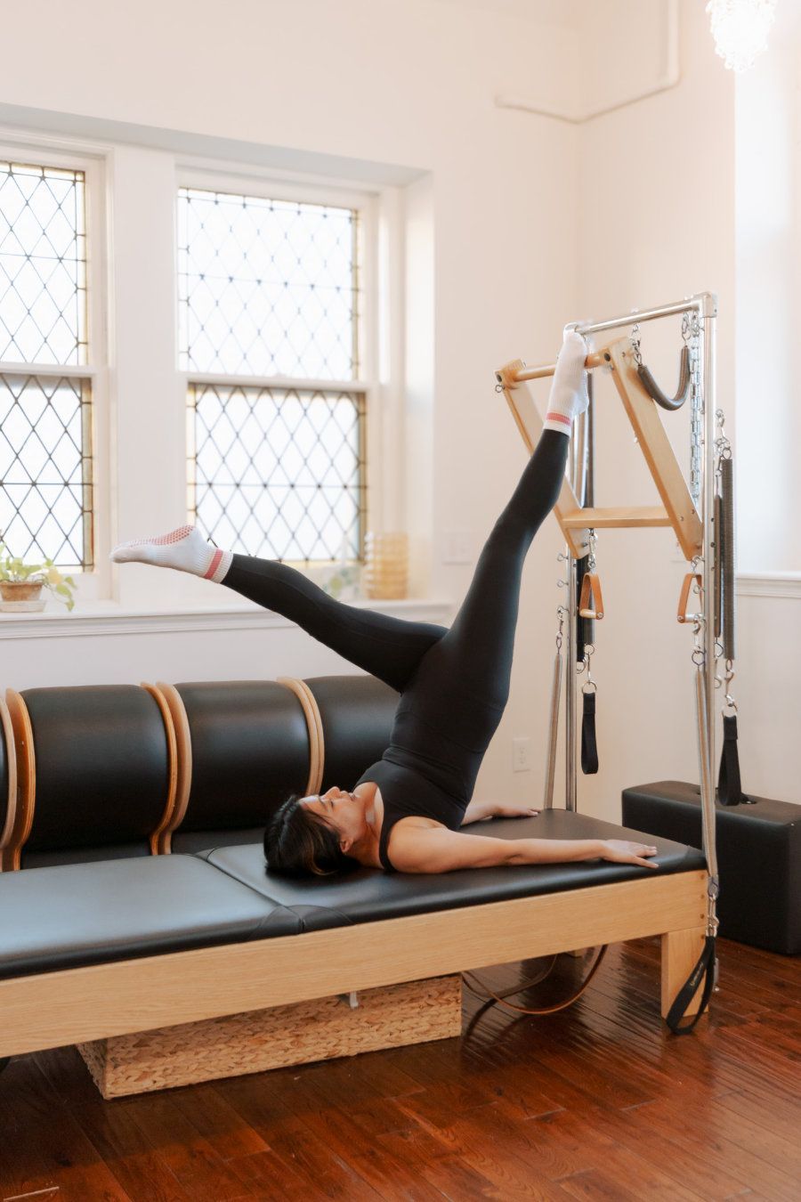 A woman is doing exercises on a pilates machine