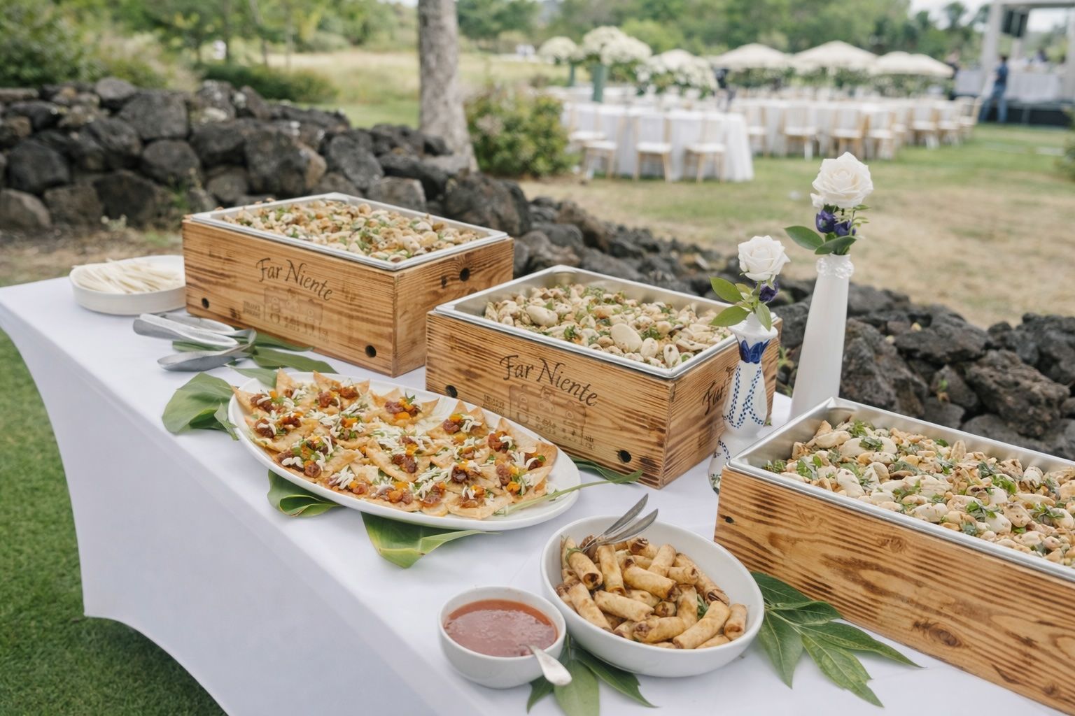 Outdoor buffet table with wicker baskets of food, pastries, and fruit in a garden setting