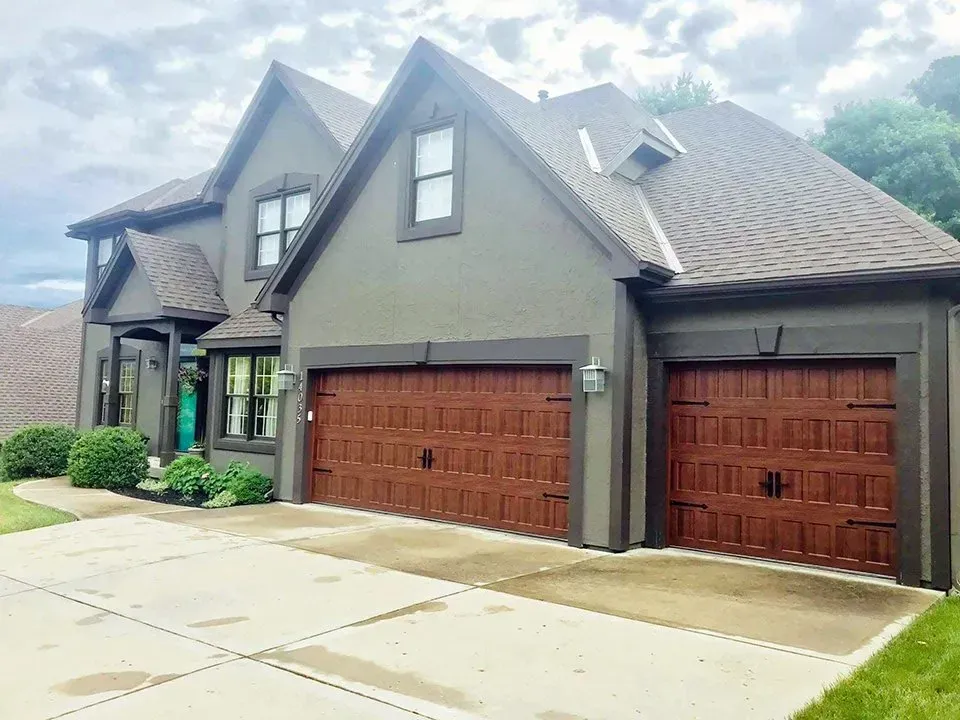 A large house with two garage doors and a driveway.