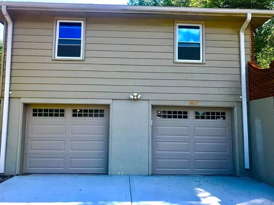 A house with two garage doors and two windows
