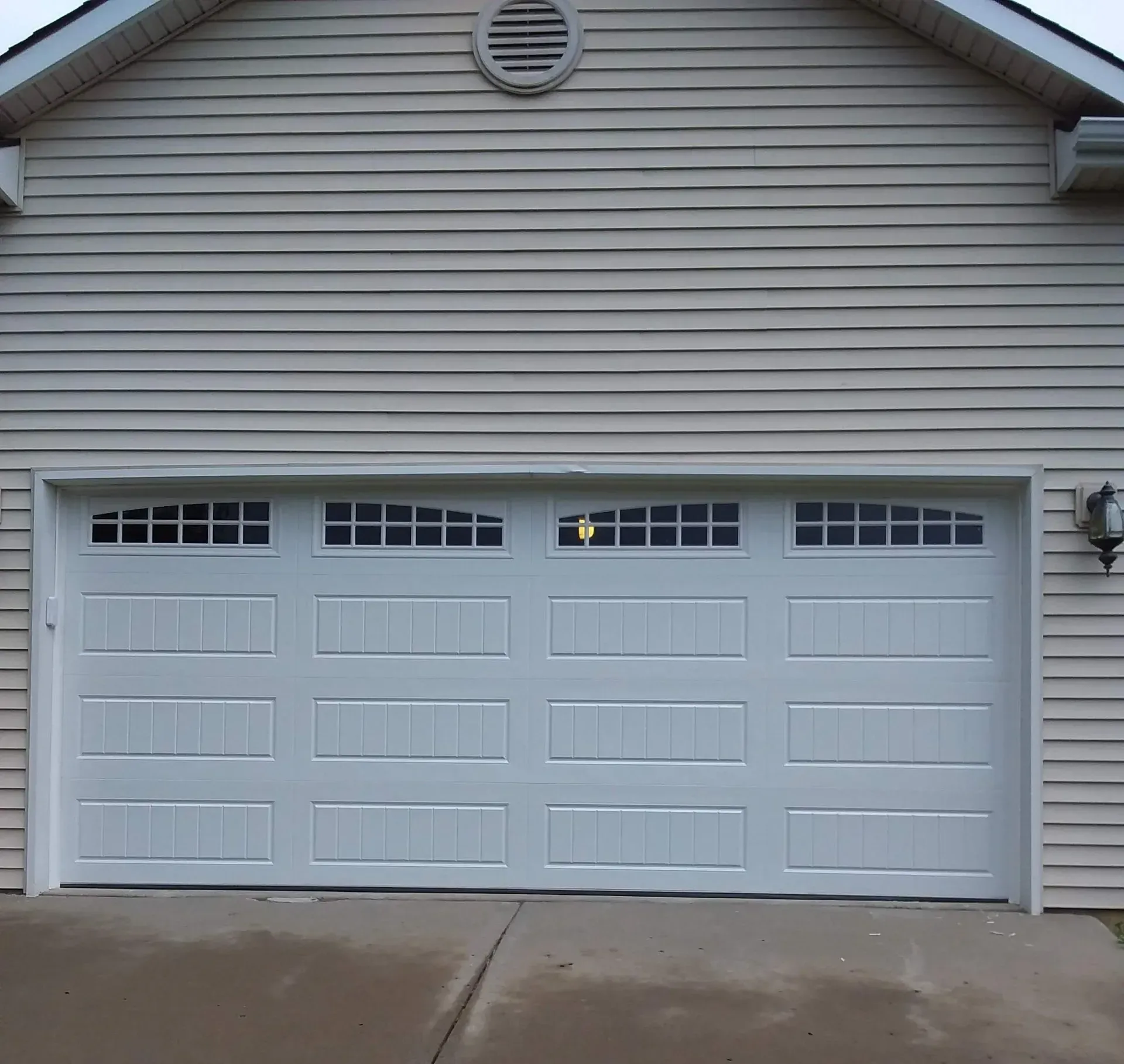 A white garage door is open on a house