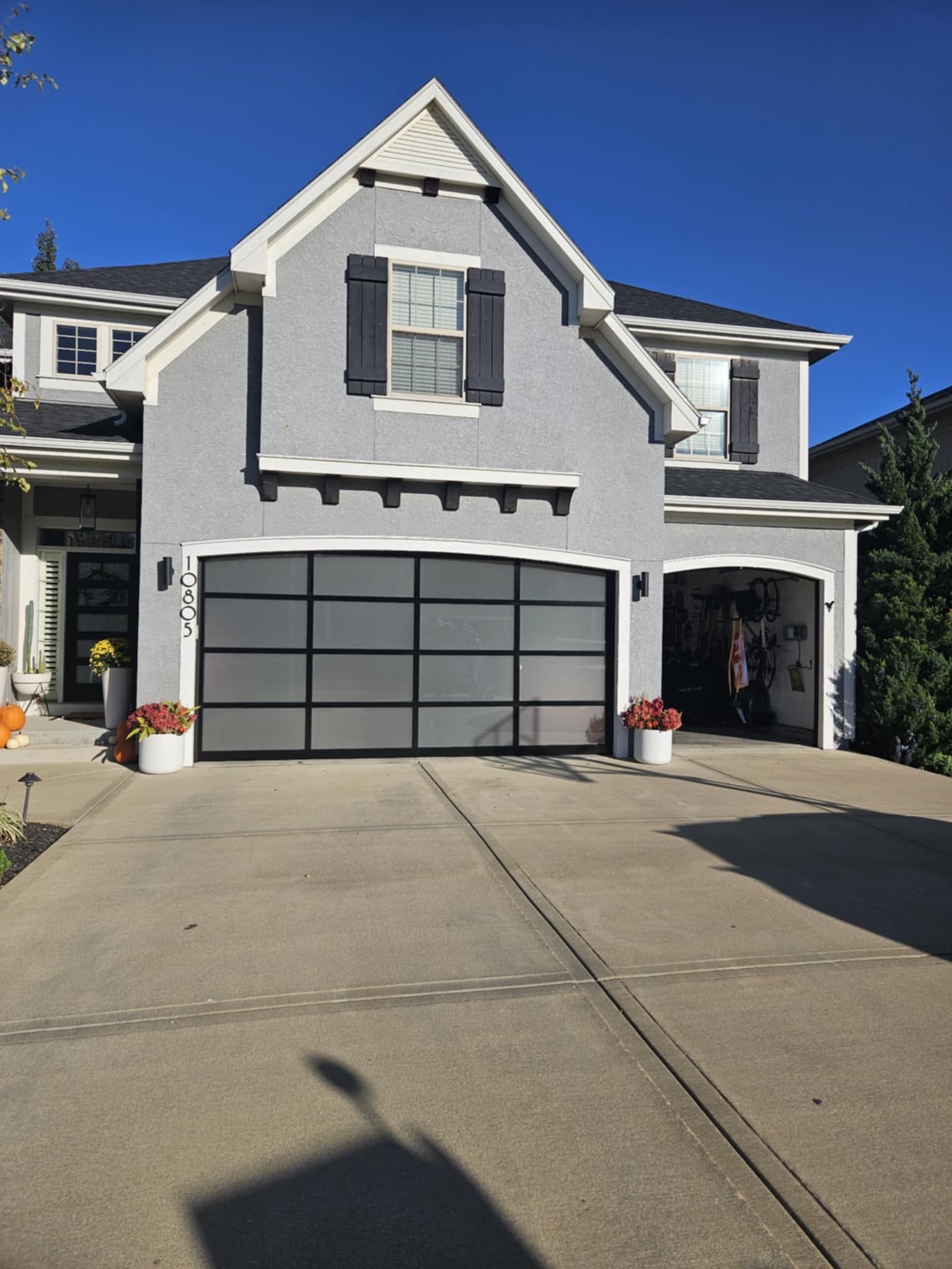 A large gray house with a black garage door