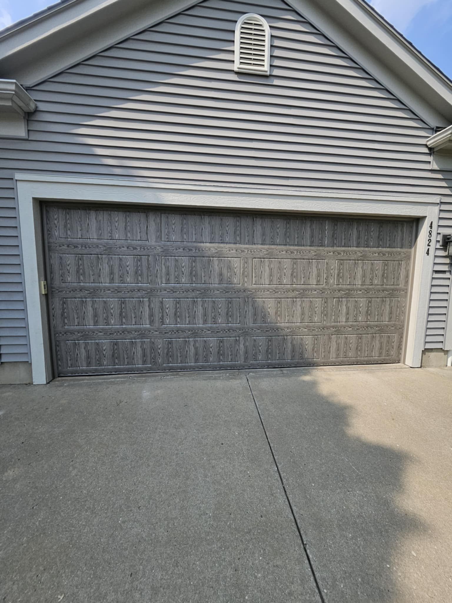 A garage door is open on the side of a house.