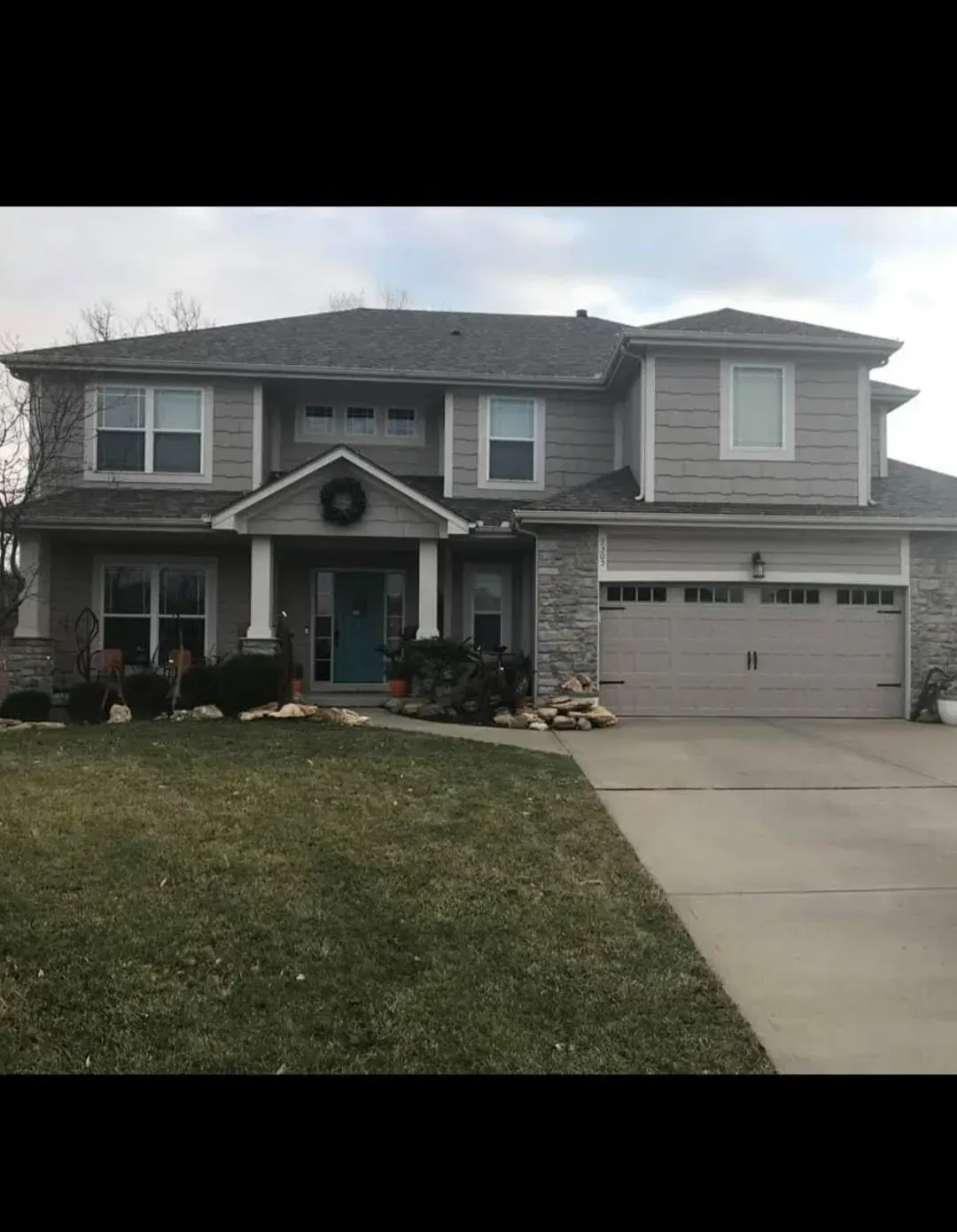 A large house with a blue door and a wreath on the front door.