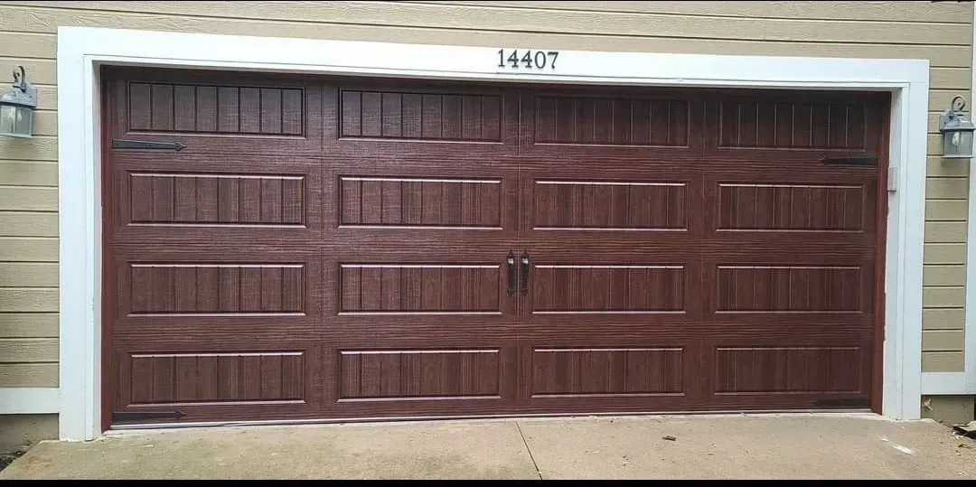 A brown garage door is sitting on the side of a house.