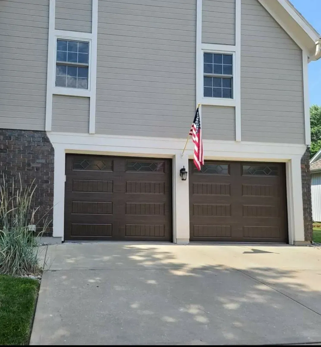 A house with two garage doors and an american flag
