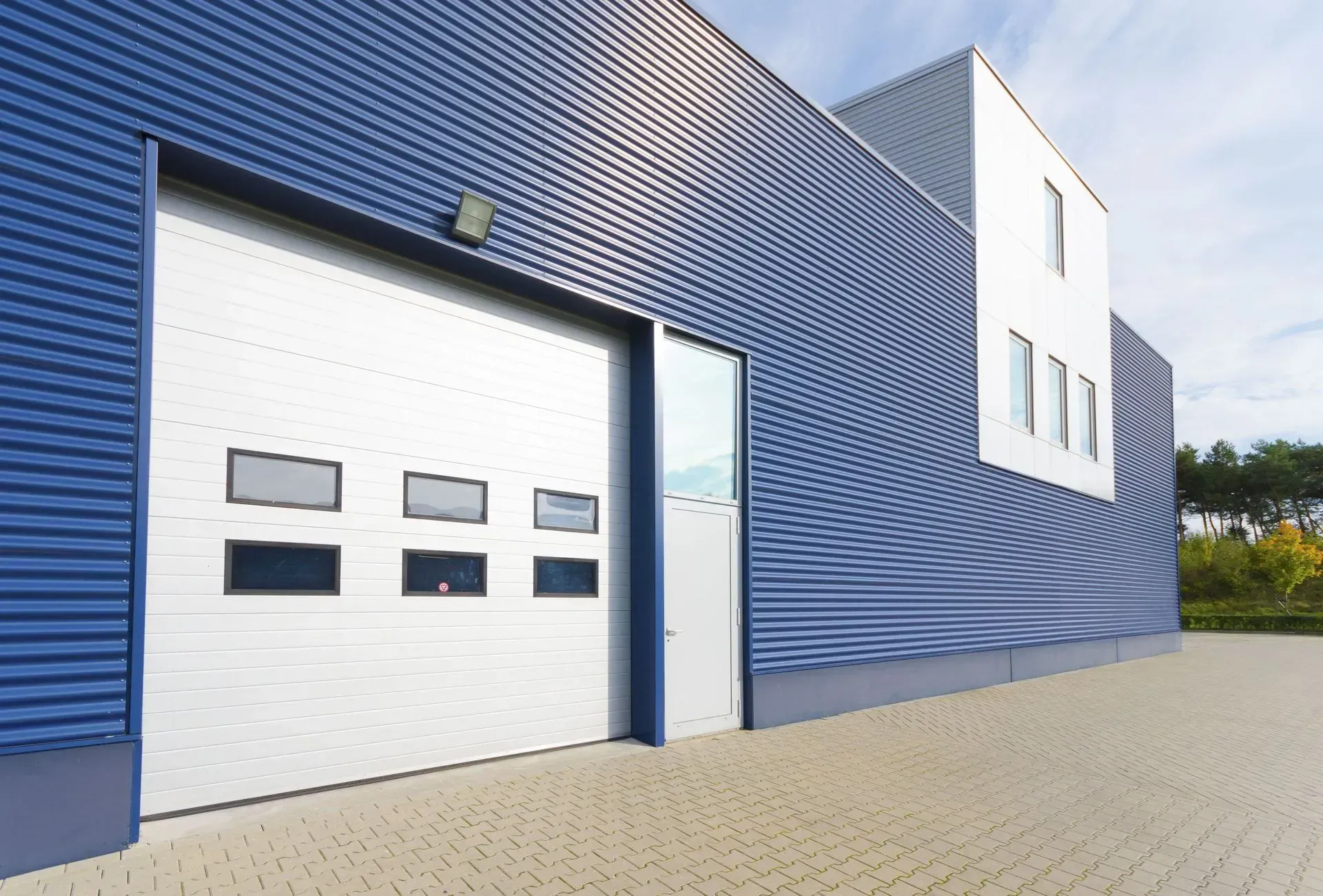 A blue and white building with a white garage door