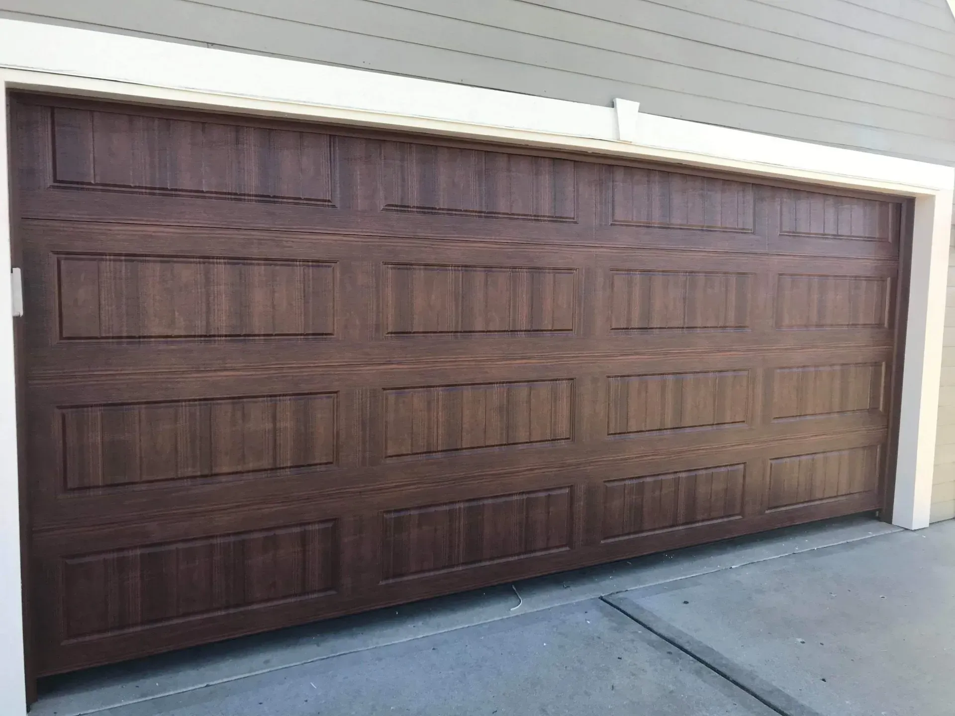 A large wooden garage door is sitting on the side of a house.