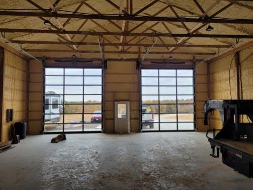 A large empty garage with a lot of windows and doors.