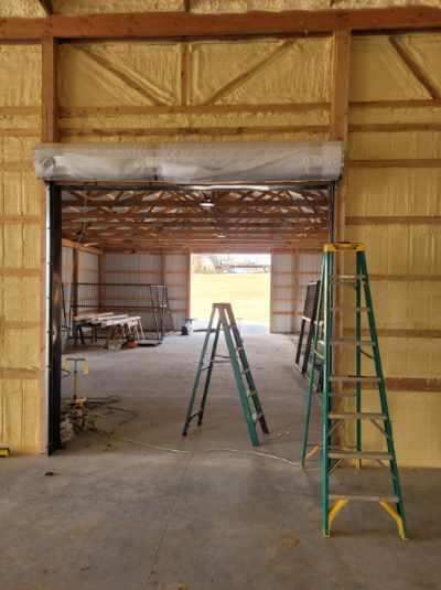 A ladder is sitting next to a door in a building.