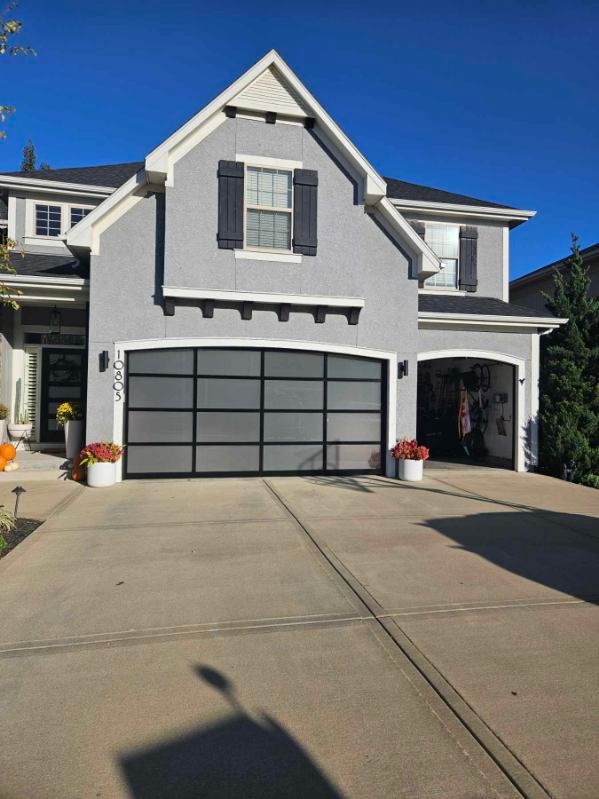 A large gray house with a black garage door.