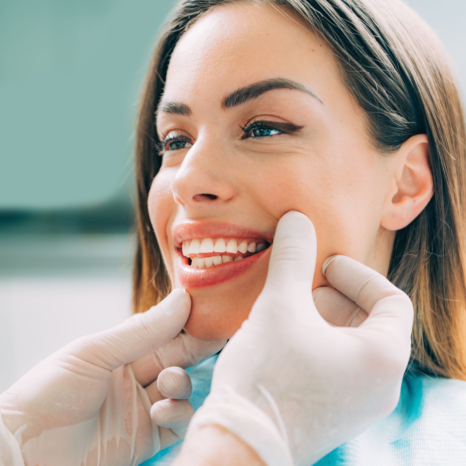 Woman receiving a dental check-up & consultation from a cosmetic dentist in a bright modern clinic