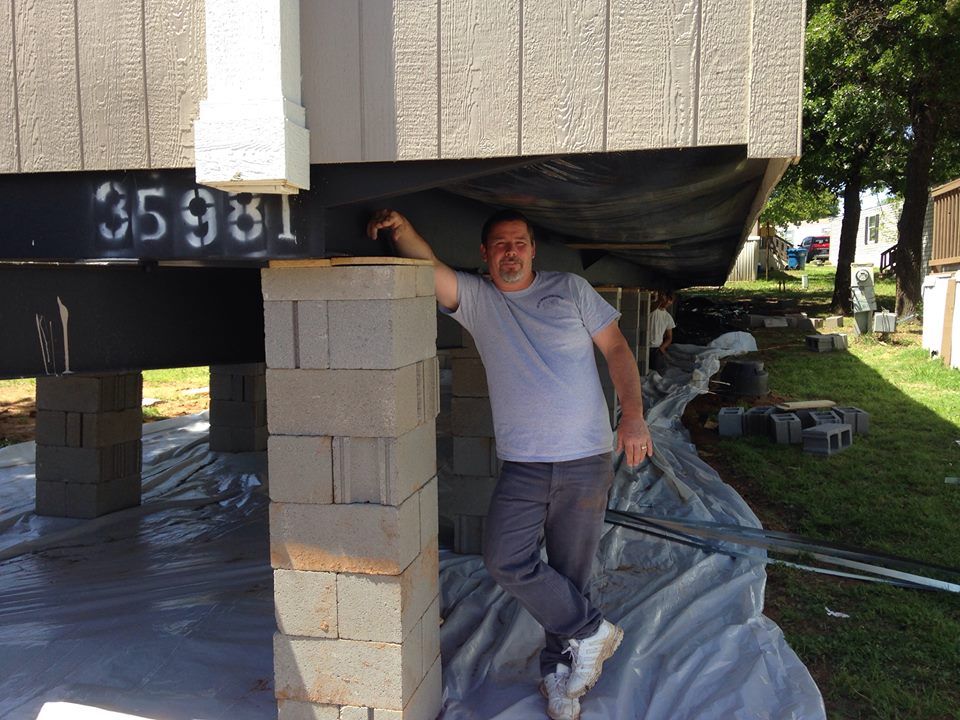 Man Leaning on Stacked Hollow Blocks — Tecumseh, OK — Jacks Mobile Home Service