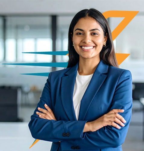 Mujer con un blazer azul y brazos cruzados sonriendo en un entorno de oficina.