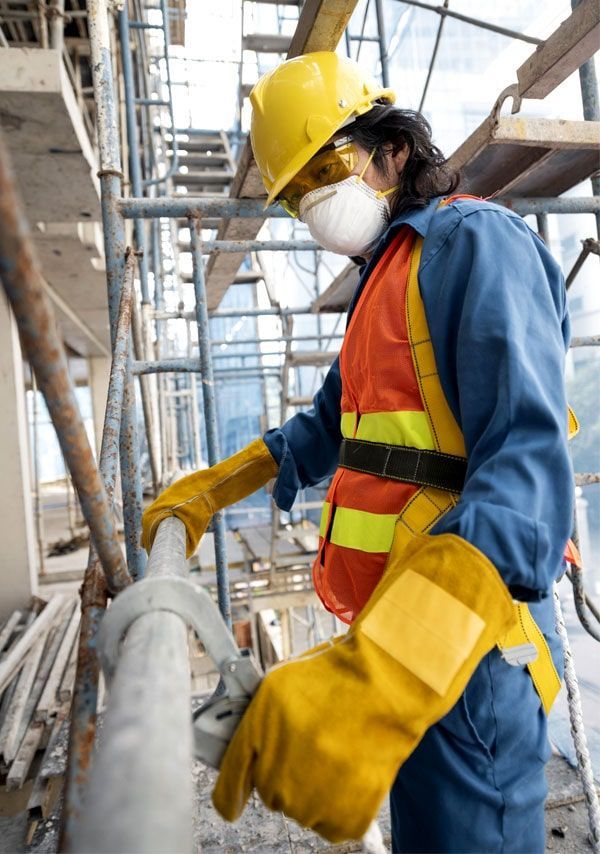 Trabajador de la construcción con equipo de seguridad en un andamio.