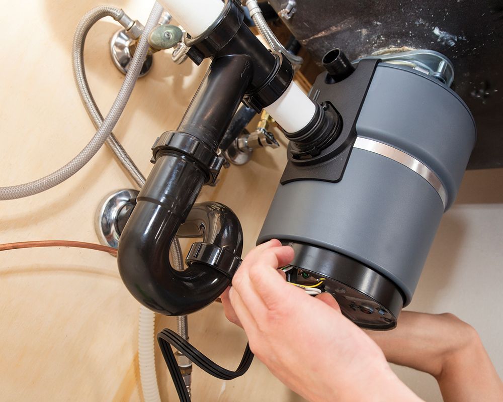 Worker Repairing Garbage Disposal – Cleburne, TX – Mr. Bill's Plumbing