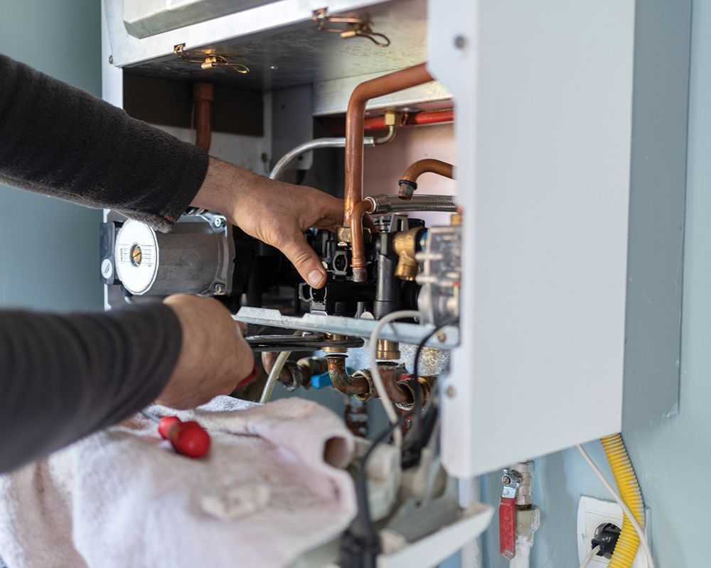 Worker Repairing Water Heater – Cleburne, TX – Mr. Bill's Plumbing