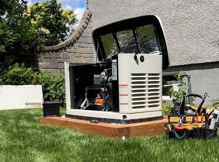 Un générateur Generac avec panneaux ouverts, posé sur une base en bois sur une pelouse à côté d'une maison, des outils à proximité.
