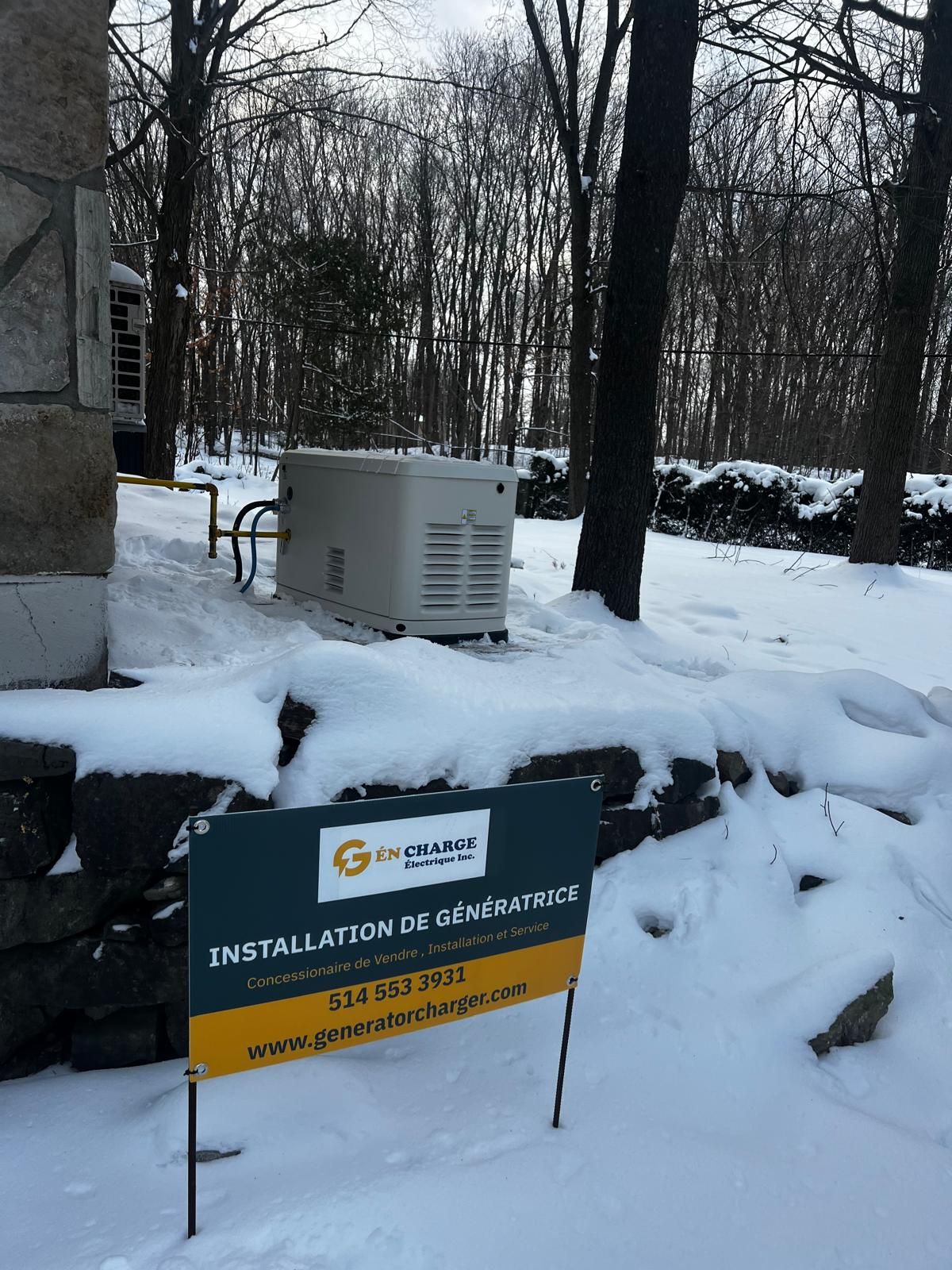 Snowy scene: A beige generator sits near a building and trees. A sign reads