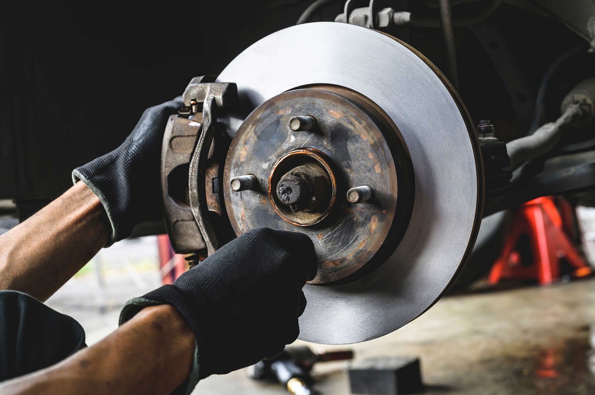 A man is fixing a brake disc on a car.