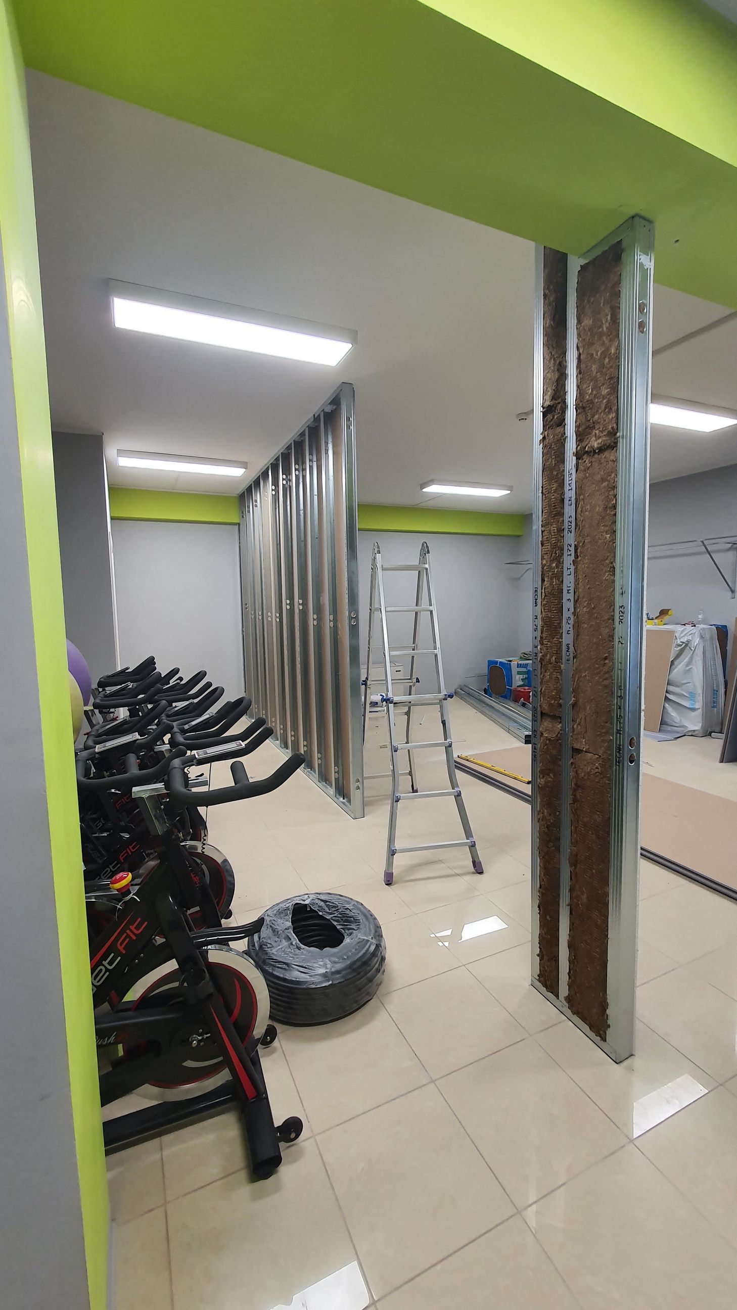 Una fila di cyclette sono allineate in una palestra in costruzione.