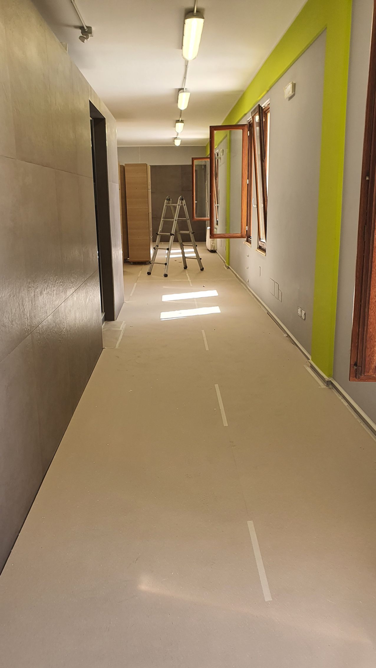 Un lungo corridoio con una finestra al centro.