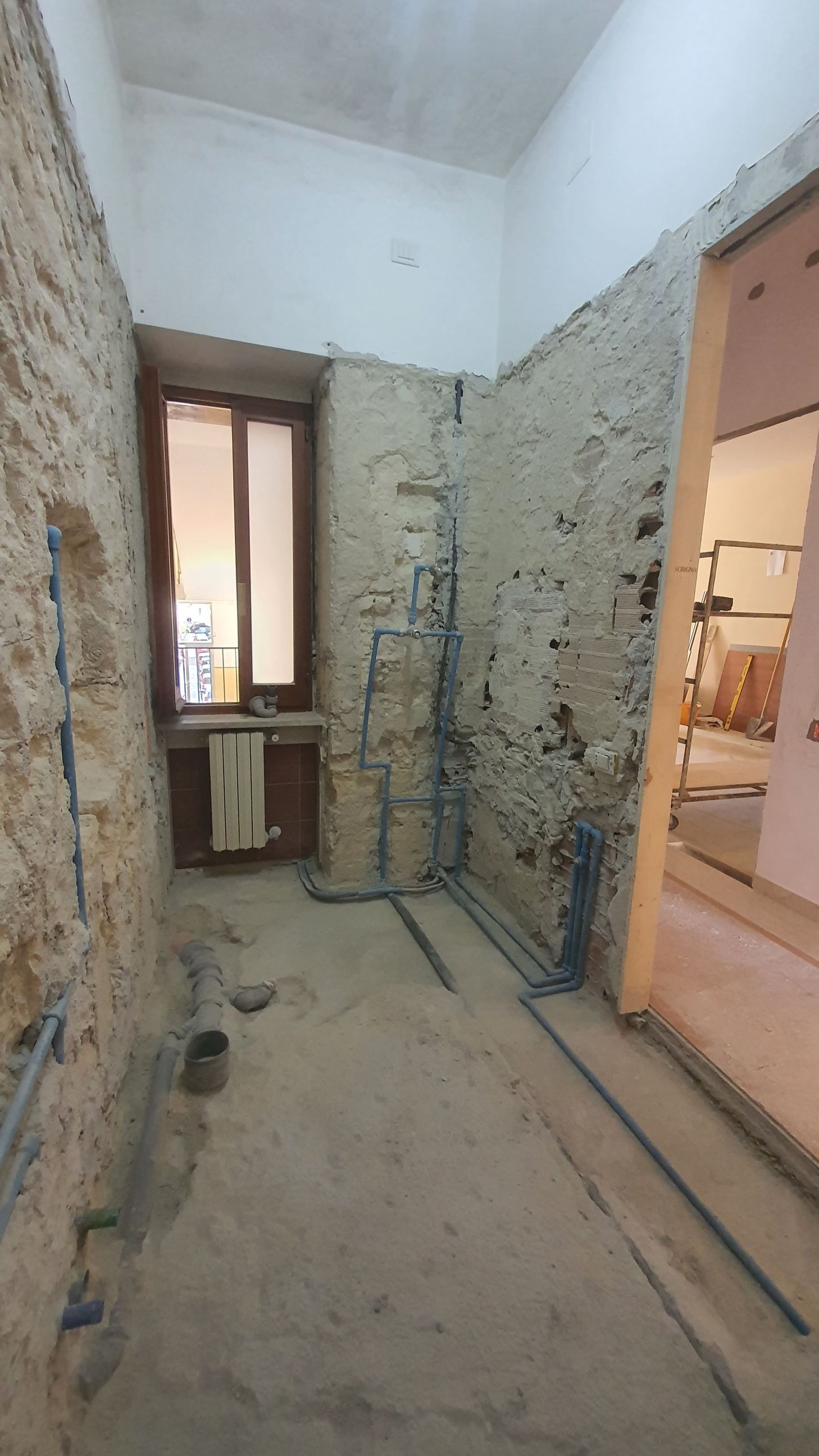 Un bagno in costruzione con lavandino e finestra.