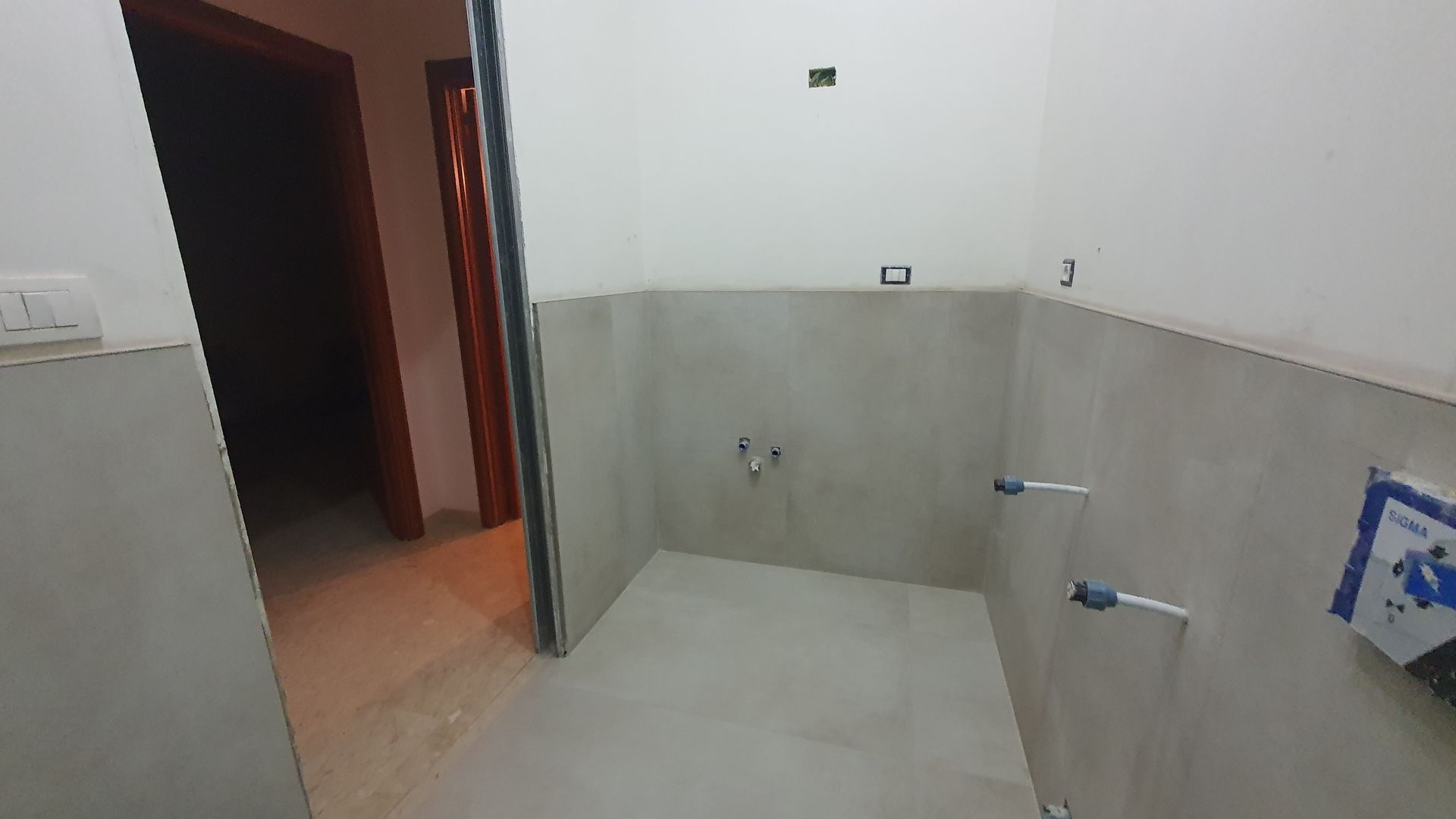 Un bagno con un lavandino e una porta in una casa in costruzione.
