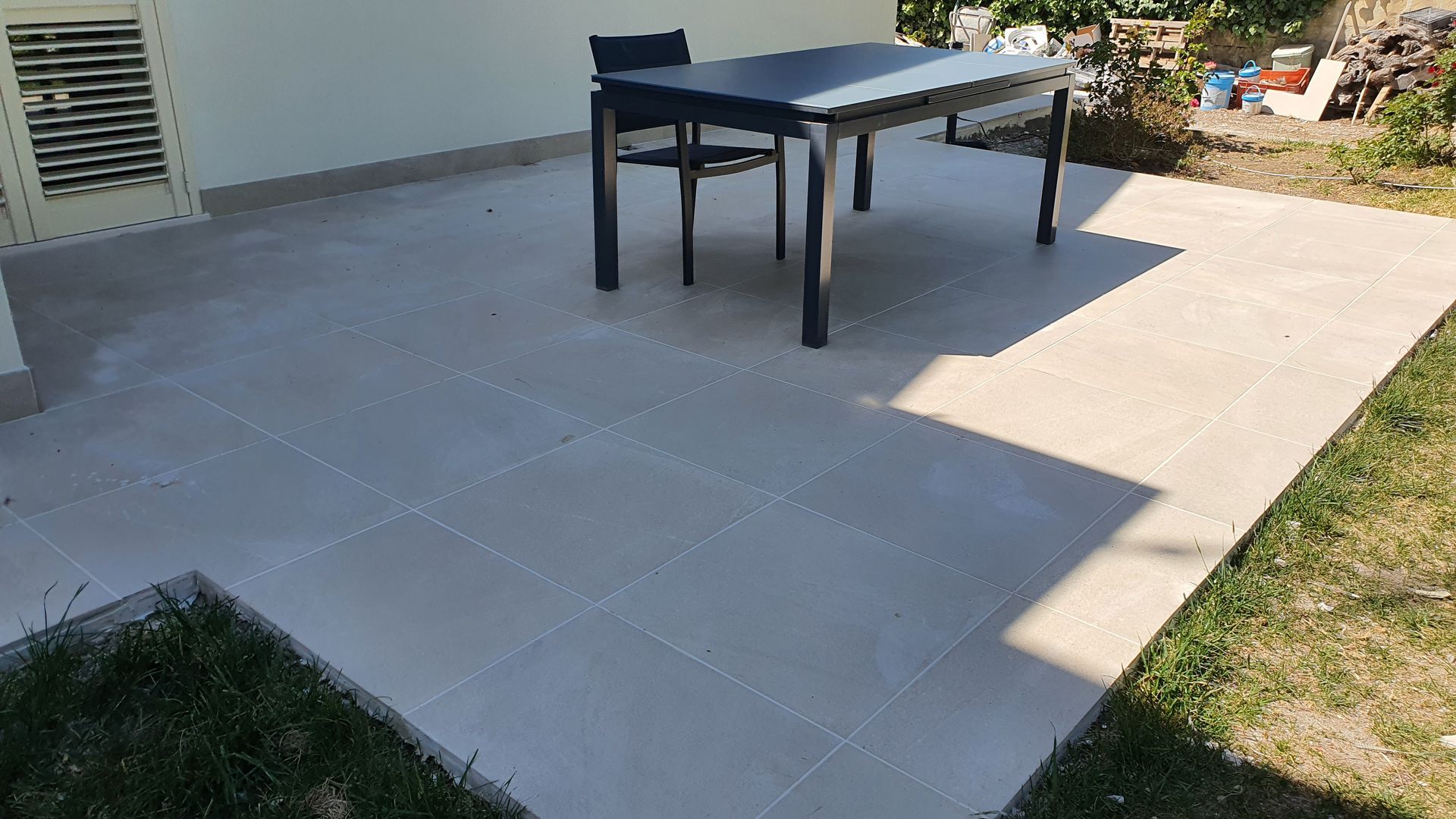 C'è un tavolo e delle sedie nel patio.