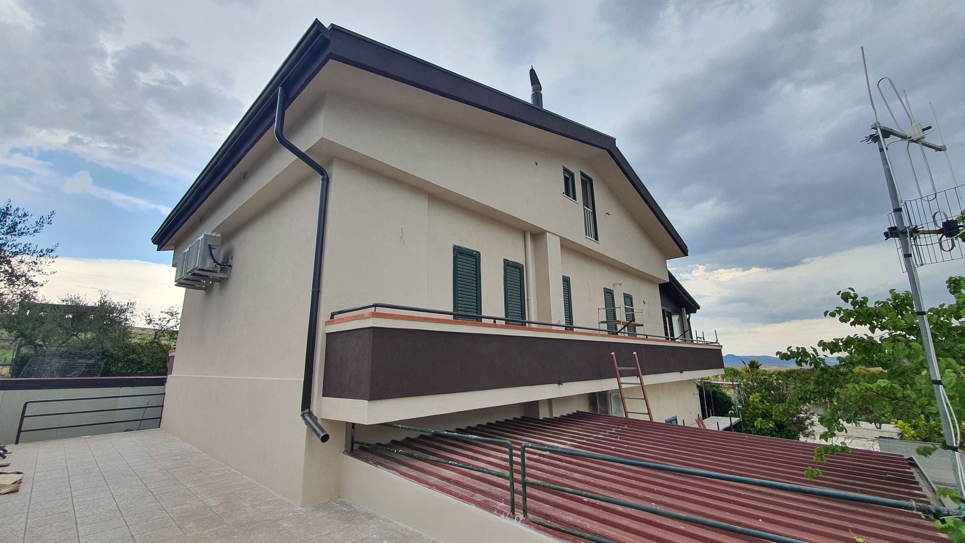 Un grande edificio bianco con un tetto marrone e un balcone