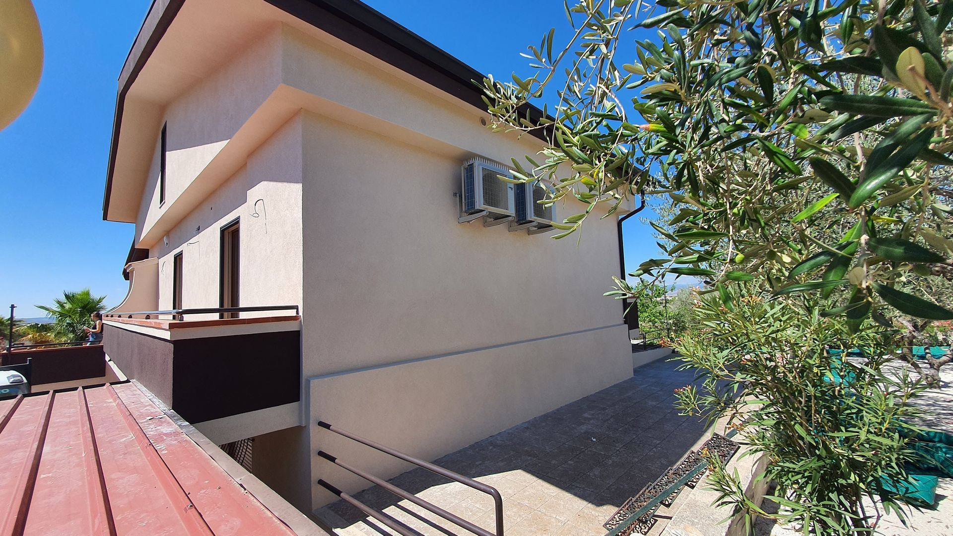 Una casa con delle scale che portano ad essa e un albero di fronte