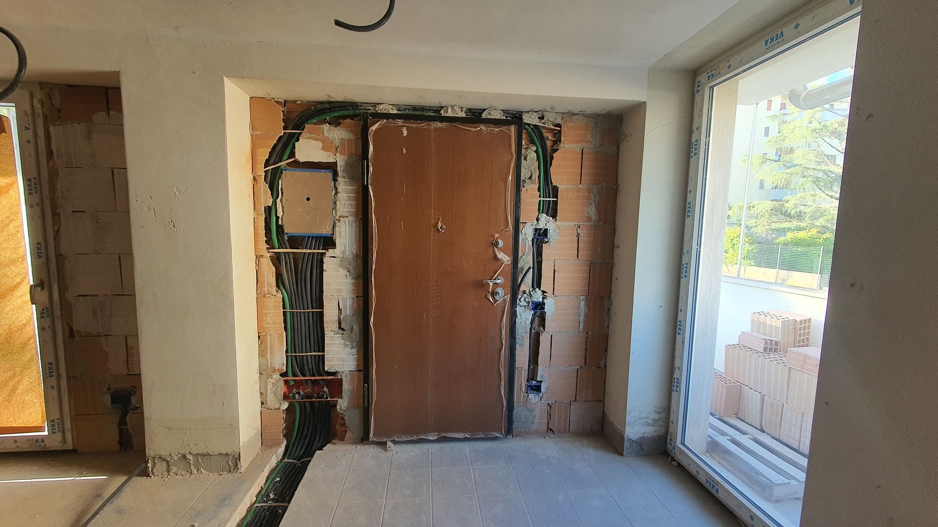 Una stanza vuota con una porta di legno e una finestra.