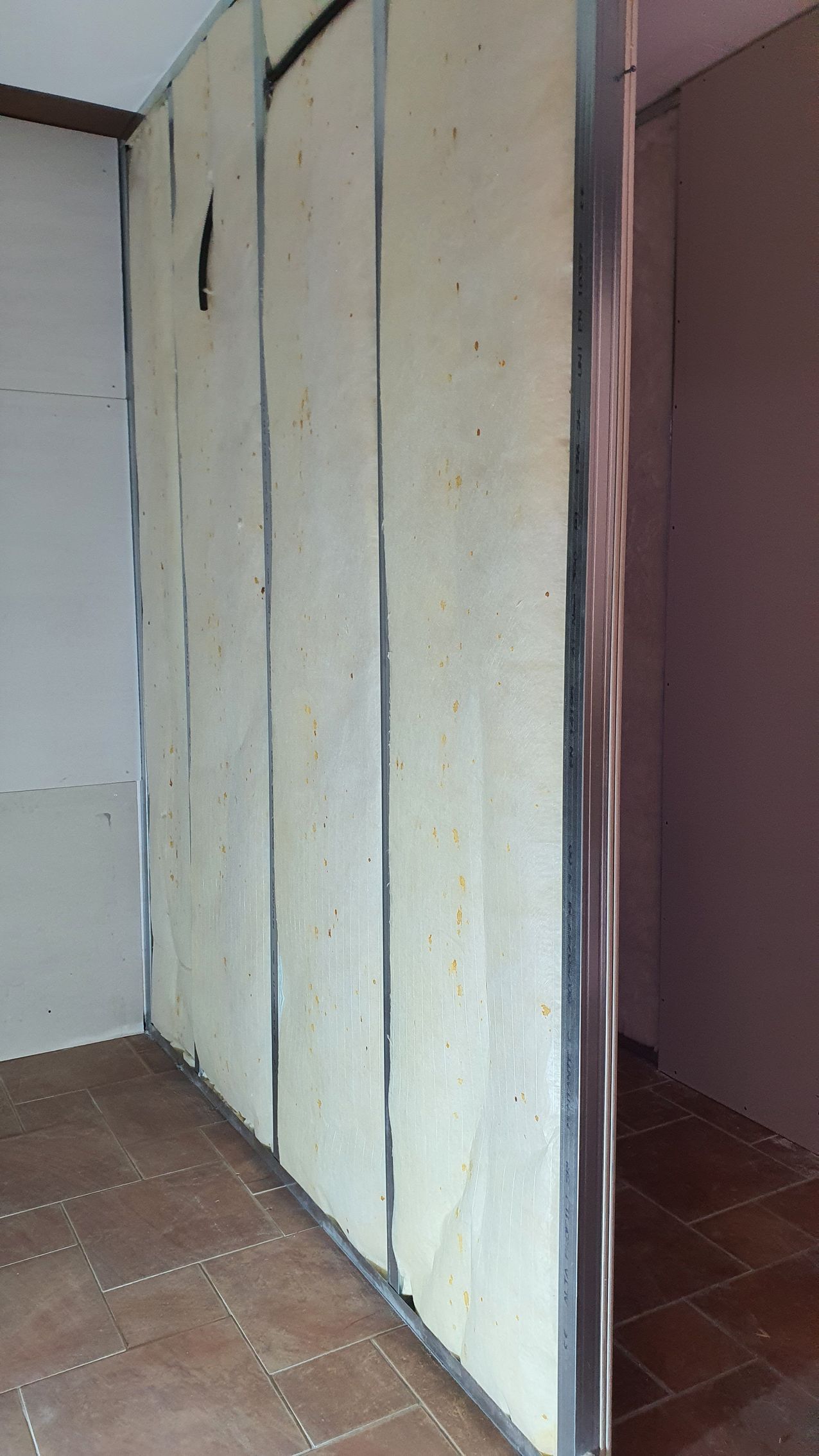 Una stanza con una fila di pareti bianche e una porta.