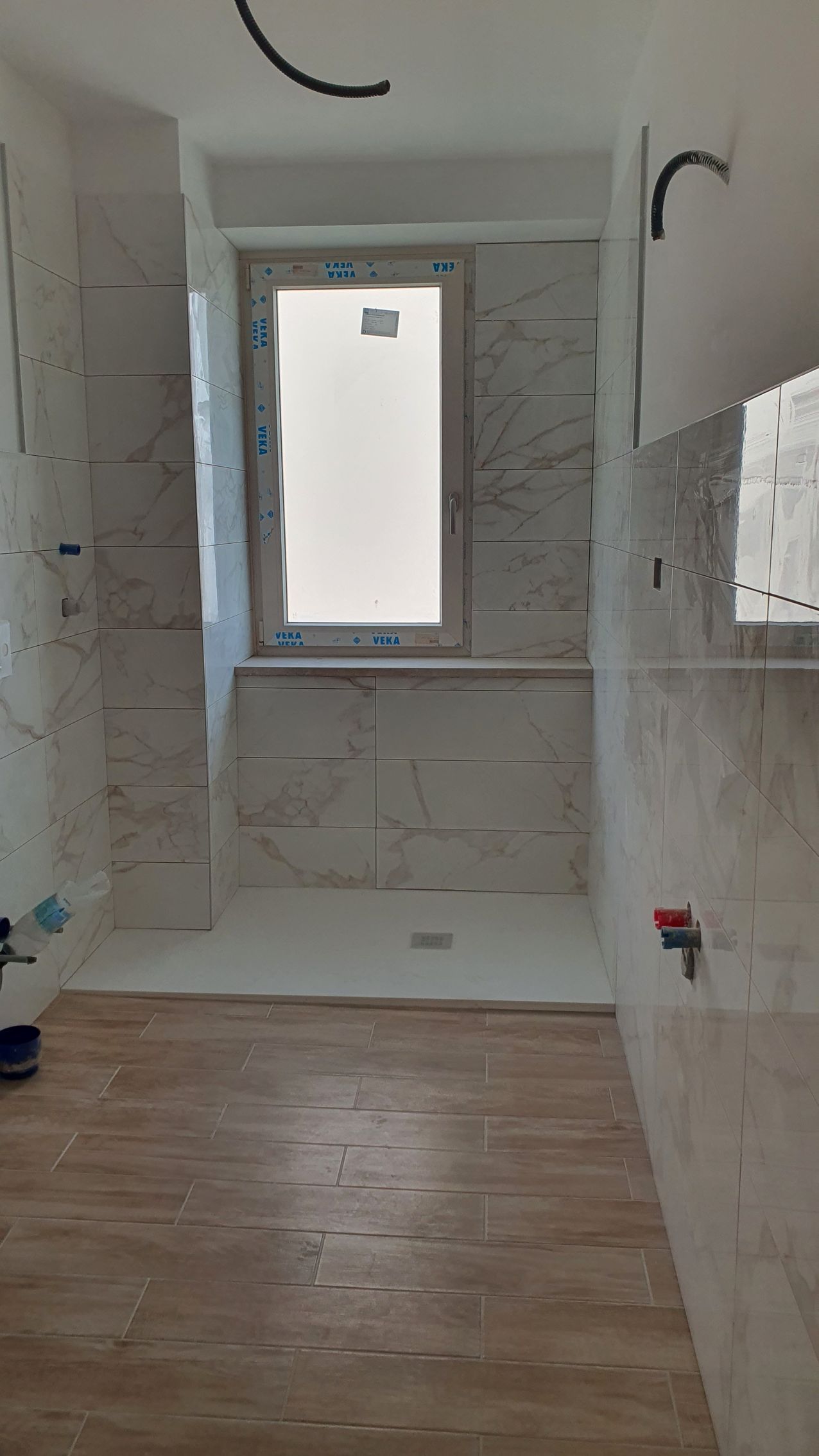 Un bagno con finestra e cabina doccia.