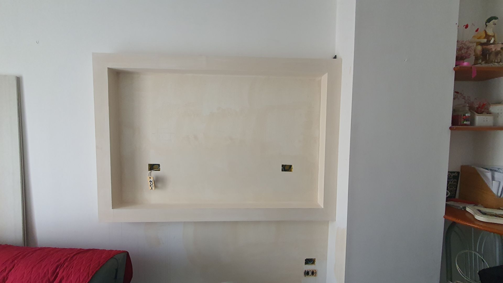 Un soggiorno con una TV a schermo piatto montata sulla parete.